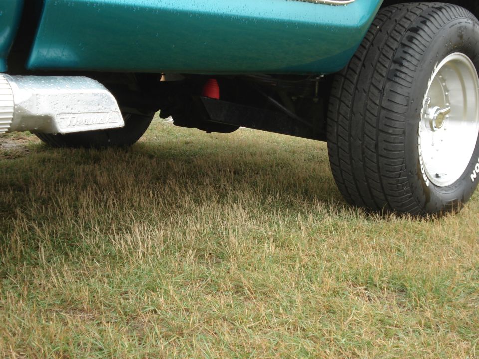 close-up of truck's rear tire, exhaust tip, and suspension components