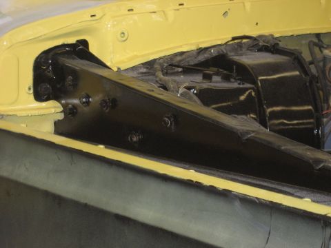 1978 Ford Bronco - Close-up view of a black bracket and wiring within a yellow engine bay.