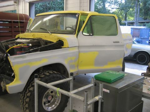 1978 Ford Bronco - This 1978 Ford Bronco is undergoing bodywork, with primer visible on its panels and the hood open.