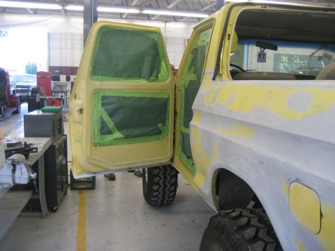 1978 Ford Bronco - 1978 Ford Bronco undergoing bodywork and preparation for paint. Doors are open, revealing masked interior panels.