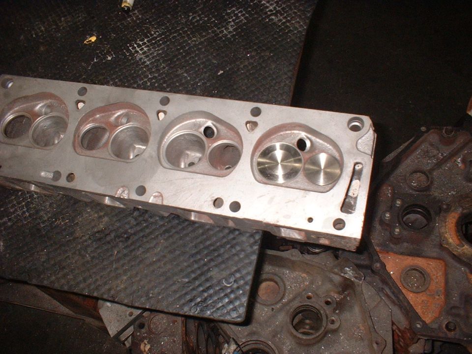 Close-up of an aluminum engine cylinder head with intake and exhaust ports visible