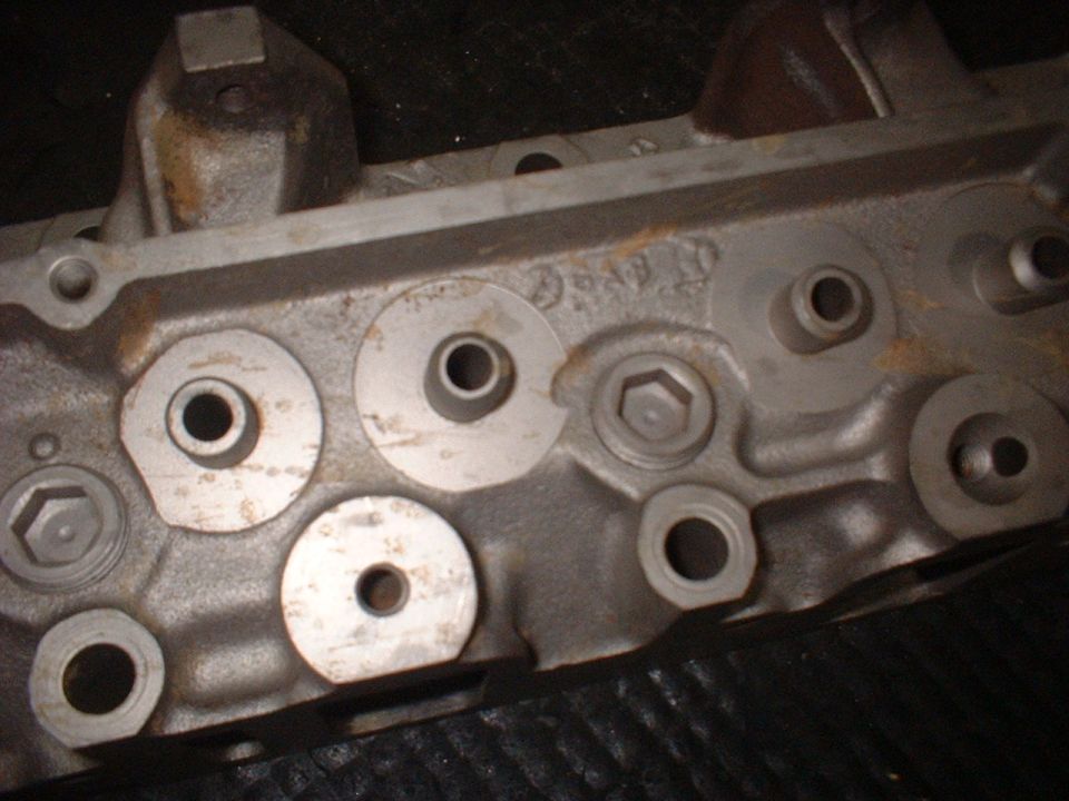 Engine cylinder head with bolt holes and ports