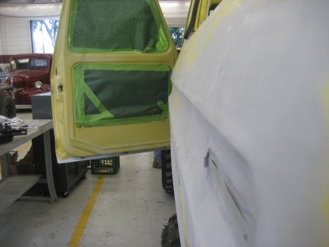 1978 Ford Bronco - Vehicle body parts being prepped for paint in a workshop. Another vehicle is visible in the background.