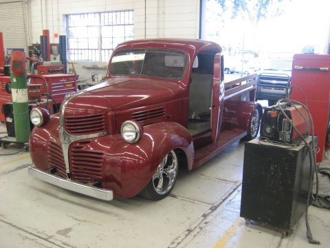 1978 Ford Bronco - Customized red pickup truck in a garage setting with welding equipment visible.