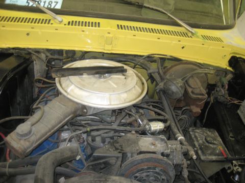 1978 Ford Bronco - Engine bay of a yellow vehicle, showing the air cleaner, brake booster, and various hoses and wires.