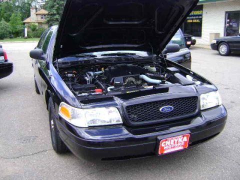 2003 Ford Crown Victoria - A black 2003 Ford Crown Victoria is shown with its hood open, revealing the engine compartment.