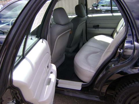 2003 Ford Crown Victoria - Interior view of a black sedan with light gray seats and white door panels.