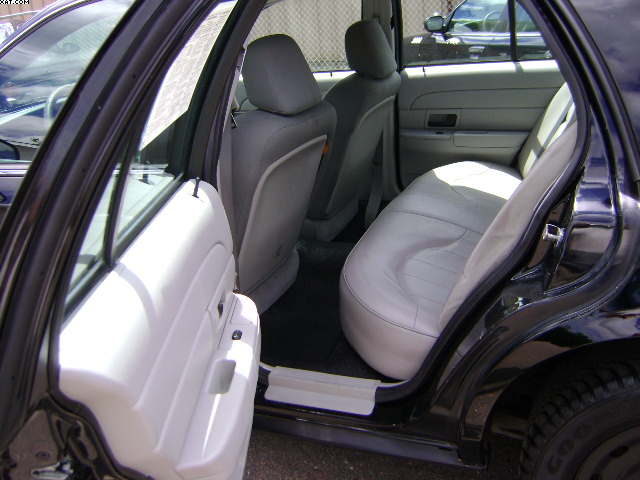Interior of a black sedan showing light gray cloth seats and white door panel