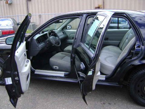 2003 Ford Crown Victoria - The interior of a 2003 Ford Crown Victoria is visible with all doors open, showing the seats and dashboard.