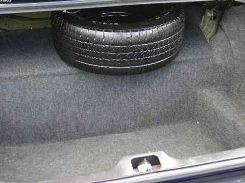 2003 Ford Crown Victoria - The spare tire is visible in the carpeted trunk of a vehicle.