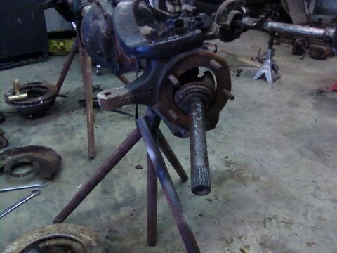 1995 Ford Bronco - Front axle assembly disassembled and supported on a stand in a workshop setting.