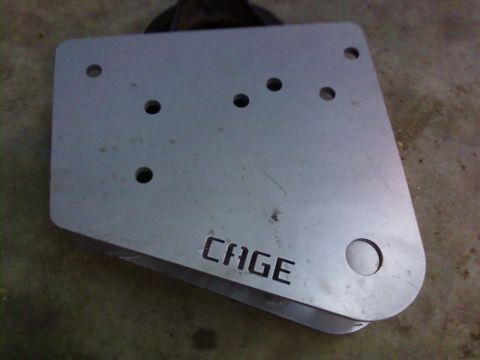 1995 Ford Bronco - A metal plate with the word CAGE laser-cut into its surface is shown.