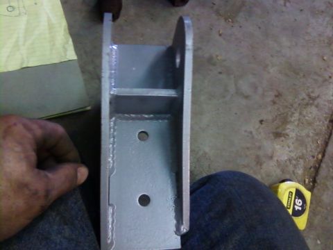1995 Ford Bronco - A metal bracket is shown, with a hand holding it and a tape measure nearby.