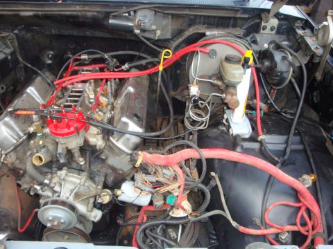 1989 Ford Bronco - Close-up view of a V8 engine, highlighting the distributor, brake booster, and various hoses and wiring.