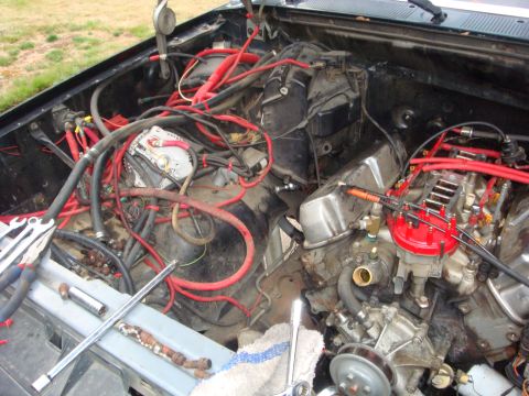 1989 Ford Bronco - A cluttered engine bay with various components and wiring visible, suggesting a complex mechanical system.