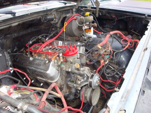 1989 Ford Bronco - The engine bay of a vehicle, Ford Racing valve covers and extensive red wiring, is shown in this image.