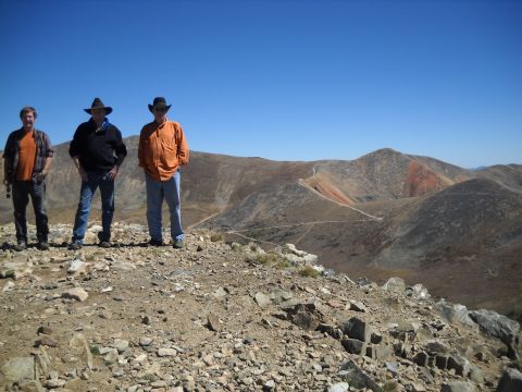 1986 Ford Bronco II - Three men pose on a mountain summit with a clear blue sky and expansive, terrain stretching out before them.