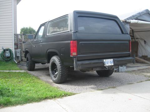 1981 Ford Bronco - This black 1981 Ford Bronco is seen from the rear, aftermarket wheels and a matte finish.