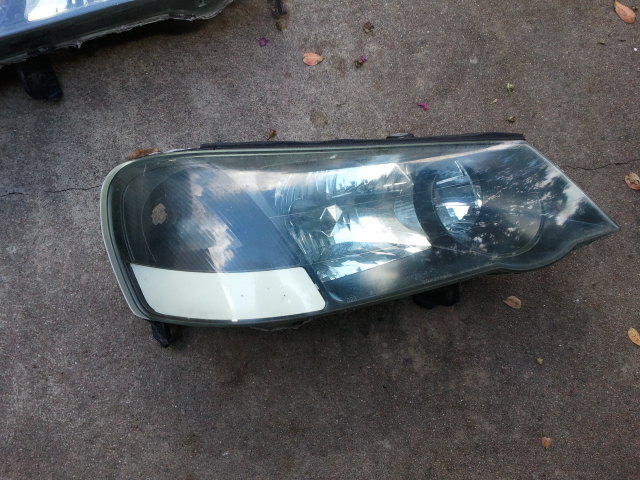 Headlight assembly with white tape on lower corner