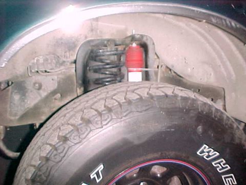 1993 Ford Bronco - This image shows the suspension components and tire of a vehicle, not a specific model year.