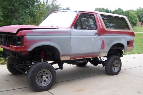 1990 Ford Bronco - This SUV is in the process of being restored, with its hood open and primer applied to the body panels.