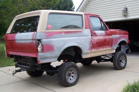 1990 Ford Bronco - This Ford Bronco is undergoing bodywork, with primer visible on the rear quarter panels and doors.
