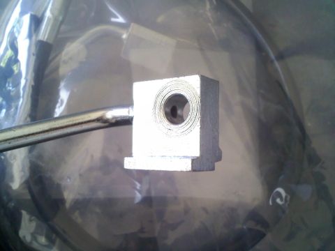 1994 Ford Bronco - This is a close-up view of a metal brake line fitting, likely for a vehicle's braking system.