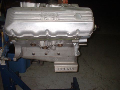 1965 Shelby Cobra - A Ford 427 SOHC engine, identified by its valve covers and "COBRA" lettering, is shown mounted on an engine stand.