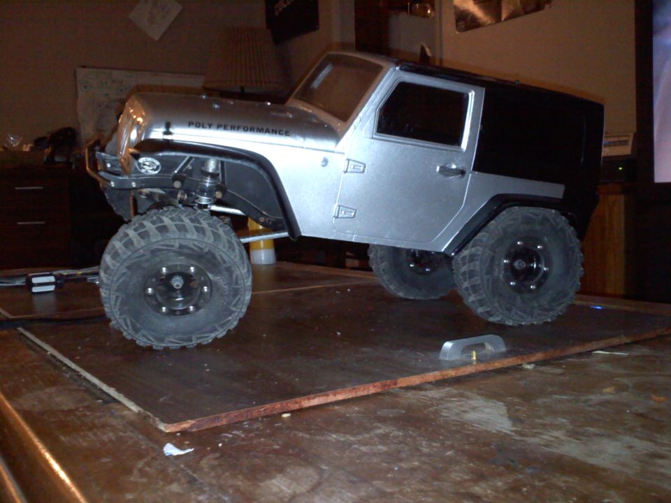 Silver and black RC car model with "POLY PERFORMANCE" text on the side