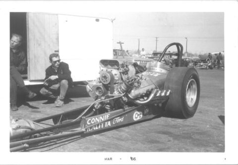 1965 Ford 427 - A dragster with a prominent engine and 'CONNIE KALITTA Ford' branding is parked near a trailer.