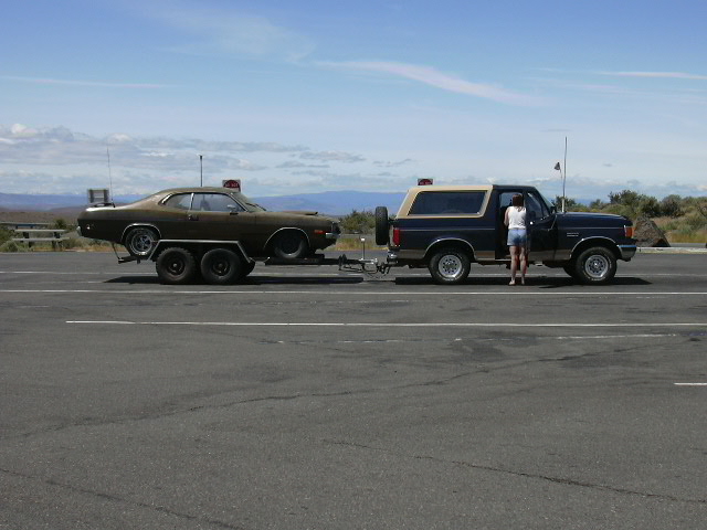 1991 Ford Bronco side view towing a brown muscle car
