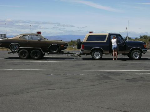 1991 Ford Bronco - A 1991 Ford Bronco is seen towing a car on a trailer.