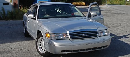 2000 Ford Crown Victoria - Front 3/4 view of a silver 2000 Ford Crown Victoria, driver's door ajar.