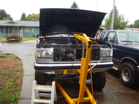 1989 Ford Bronco - Engine removal in progress on a Ford F-Series truck, with a second truck visible.