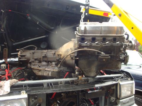 1989 Ford Bronco - The engine and transmission are being removed from the vehicle, likely for repair or replacement.