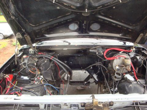 1989 Ford Bronco - Engine bay of a 1989 Ford Bronco, with the hood raised, revealing the engine compartment.