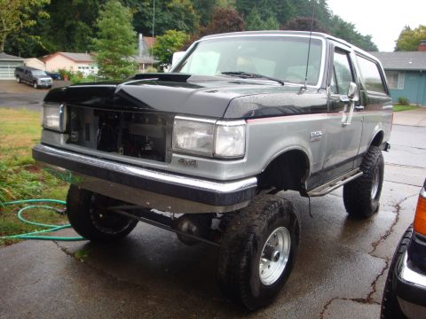 1989 Ford Bronco - This lifted 1989 Ford Bronco features a two-tone paint scheme and prominent aftermarket hood scoop.