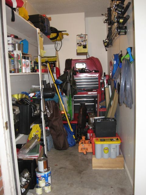 1986 Ford Bronco - A cluttered storage closet contains various items, including a red toolbox and fishing equipment.