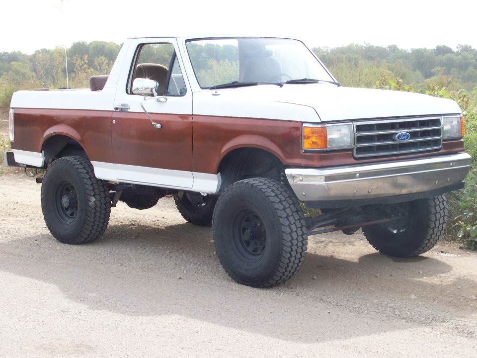 Lifted two-tone Ford Bronco with brown and white paint, off-road tires