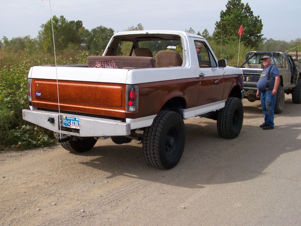 Rear view of lifted 1989 Ford Bronco with two-tone paint and aftermarket bumper