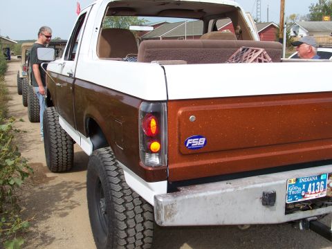 1989 Ford Bronco - A 1989 Ford Bronco is parked in a line with other vehicles, with two men standing nearby.