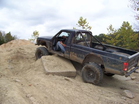 1989 Ford Bronco - This Jeep Comanche is navigating a challenging off-road course with a driver behind the wheel.