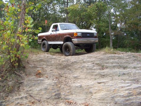 1989 Ford Bronco - 1989 Ford Bronco navigating a challenging rocky trail during an off-road excursion.