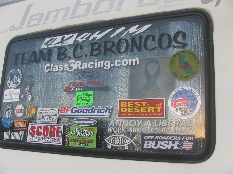 Trailer window covered in racing stickers including Team B.C. Broncos and BFGoodrich