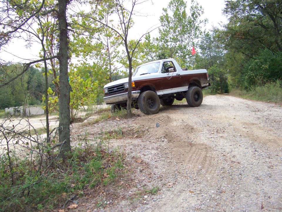 Brown and white 1987 Ford Bronco on a dirt road