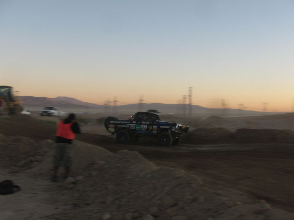 Number 300 off-road race truck on desert track at dusk