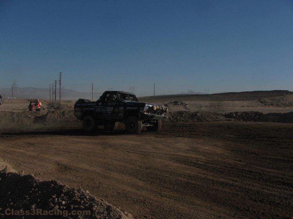 Number 300 off-road race truck on a desert dirt course in daylight