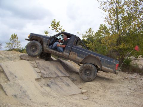 1989 Ford Bronco - Pickup truck navigates an off-road obstacle course with wooden ramps.