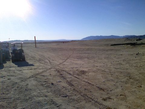 1989 Ford Bronco - Golf carts sit idle in a vast, arid landscape under a clear blue sky.