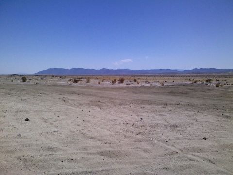 1989 Ford Bronco - A wide desert scene under a clear blue sky, with a watermark indicating the source as SUPERMOTORS.